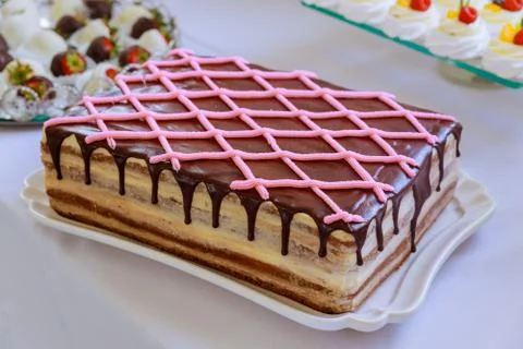 Rectangular chocolate cream cake decorated with pink buttercream. Stockfoto's