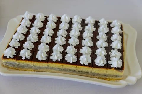 Rectangular chocolate cream cake decorated with white buttercream. Stock Photos