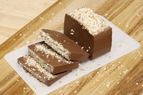 Rectangular chocolate pudding with nut crumbs cut into slices Stock Photos