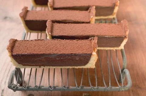 Rectangular chocolate tart with cocoa powder (in pieces) 스톡 사진