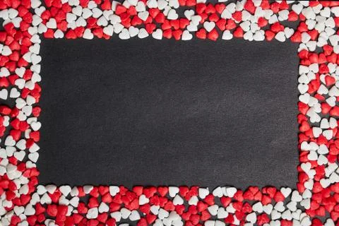 Rectangular copy space inside scattered many heart-shaped candies Stock Photos
