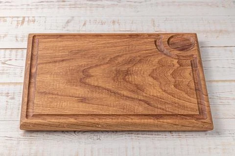 Rectangular cutting board with edging on a white wooden table. mockup of a fo 스톡 사진