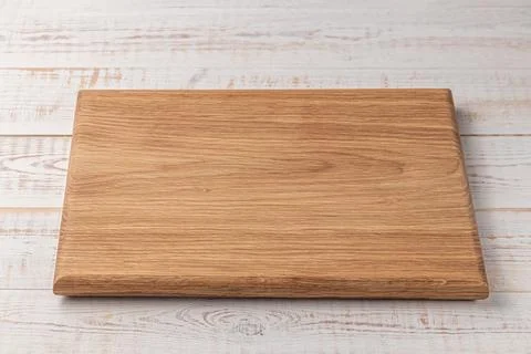 Rectangular cutting board on a white wooden table. mockup of a food backgroun Stock Photos