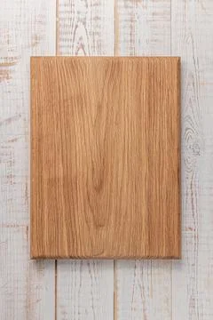 Rectangular cutting board on a white wooden table. mockup of a food backgroun Stock Photos