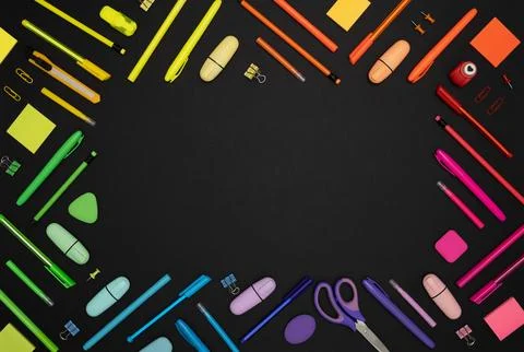 Rectangular frame of colorful rainbow stationery set on black back Stock Photos