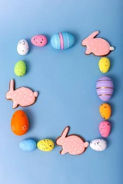 Rectangular frame of multicolored Easter eggs and gingerbread in the form of Stock Photos