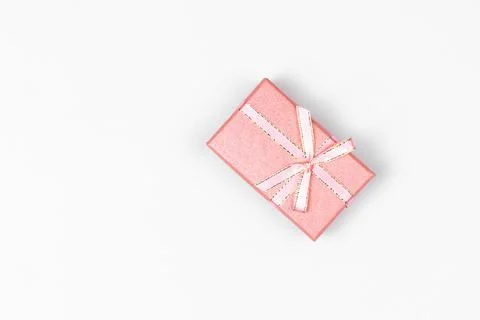 Rectangular gift box of pink pastel color with ribbon and bow close-up agains 写真素材