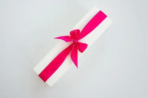 Rectangular gift box with pink ribbon on white background Stock Photos