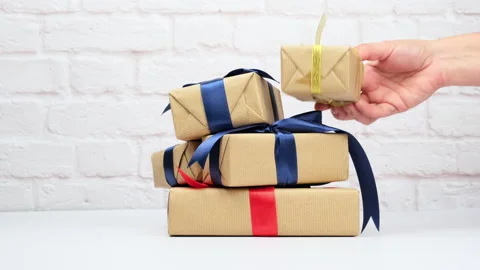Rectangular gift box wrapped in brown paper and tied with a silk ribbon with a b Stock Footage 144644422
