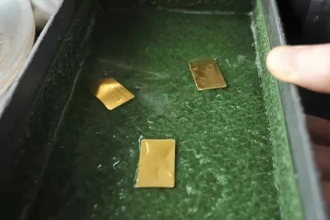 Rectangular gold plates stamped on press. Stock Photos