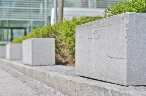 Rectangular granite fence in front of bushes 스톡 사진