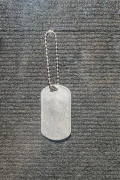 Rectangular gray dog tag with rounded corners, hanging from a chain or stri.. Stock Photos