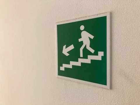 A rectangular green sign with white symbols and text, suggesting nearby sta.. Stock Photos