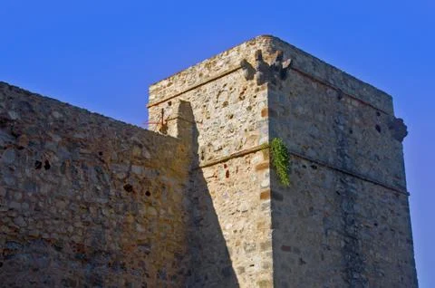 Rectangular grey tower and wall, blue sky, summer Stock Photos