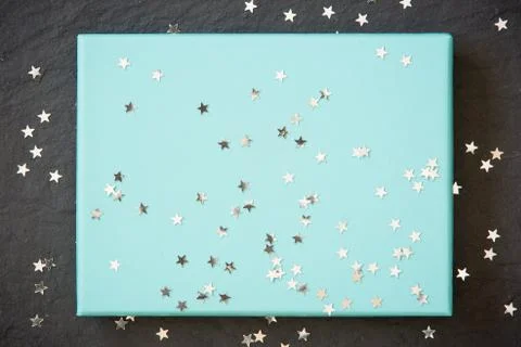 Rectangular light blue box on black background with silver stars decorations. Foto stock
