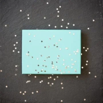 Rectangular light blue box on black background with silver stars decorations. Foto stock