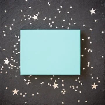 Rectangular light blue box on black background with silver stars decorations. Foto stock