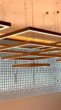 Rectangular lights suspended in layers highlight geometric precision and Stock Photos