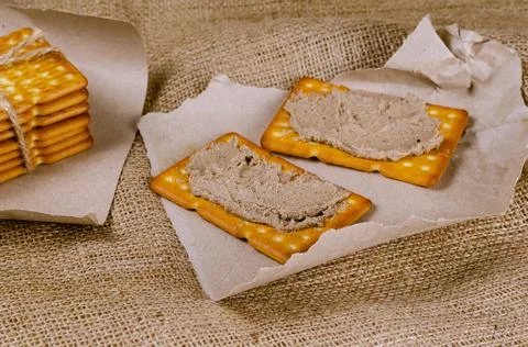 Rectangular liver pate crackers on a burlap sack. Ready-to-eat food on pieces Stock Photos
