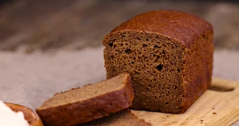 Rectangular loaf of bread on a linen cloth , black bread made from flour Video stock 271168492