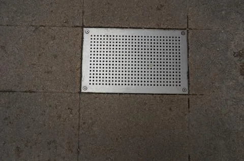 Rectangular metal grating of street drainage system Stock Photos