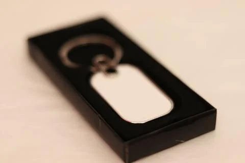 A rectangular metal keychain with a ring for a key in the box is isolated in  Stockfoto's