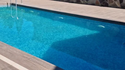 Rectangular outdoor swimming pool with crystal clear blue water, mosaic til.. Vídeos de archivo 336531385