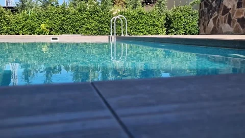 Rectangular outdoor swimming pool with crystal clear blue water, mosaic til.. Stockbeeldmateriaal 336531459
