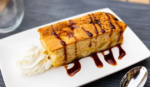 Rectangular piece of lush apple pie with delicate crispy crust and sprinkled 스톡 사진