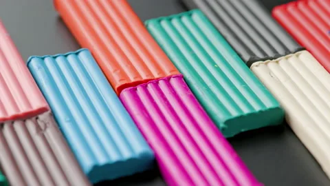 Rectangular pieces of colored plasticine rotating slowly on black flat surface Stock Footage 182861866