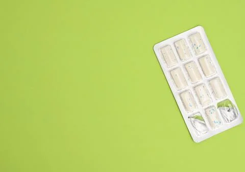 Rectangular pieces of gum in a blister pack on a green background, close up 스톡 사진