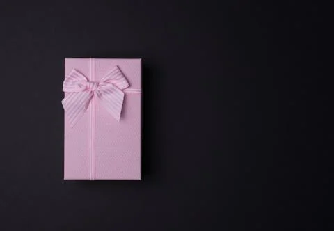 Rectangular pink gift box with bow on black background, top view Stockfoto's