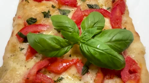 Rectangular pizza with fresh tomatoes, cheese, and basil leaves Stock Footage 328239575