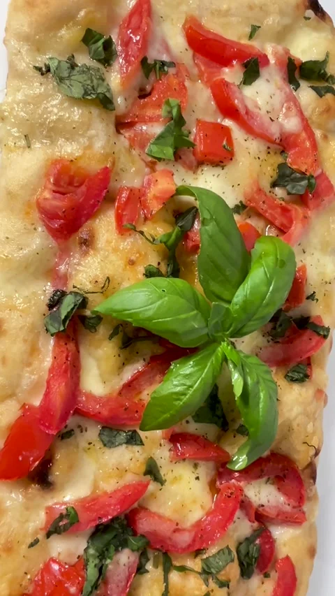 Rectangular pizza with fresh tomatoes, cheese, and basil leaves Stock Footage 328243799