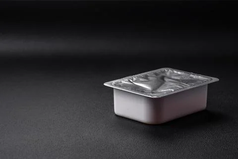 Rectangular plastic box with yogurt or cheese hermetically sealed with a fo.. Stock Photos