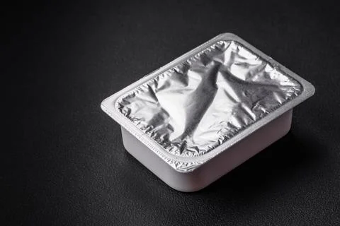Rectangular plastic box with yogurt or cheese hermetically sealed with a fo.. Stock Photos