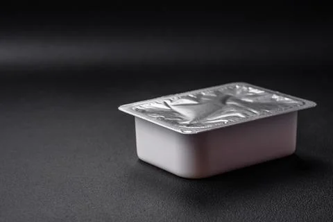 Rectangular plastic box with yogurt or cheese hermetically sealed with a fo.. Stock Photos
