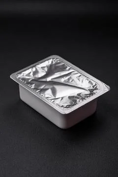 Rectangular plastic box with yogurt or cheese hermetically sealed with a fo.. Stock Photos