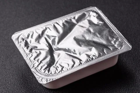 Rectangular plastic box with yogurt or cheese hermetically sealed with a fo.. Stockfoto's