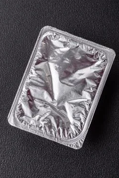 Rectangular plastic box with yogurt or cheese hermetically sealed with a foil Stock Photos