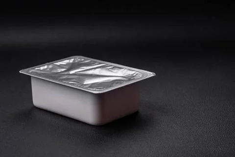 Rectangular plastic box with yogurt or cheese hermetically sealed with a f... Stockfoto's