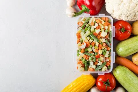 Rectangular plastic container with mix of frozen vegetables flat lay  Stock Photos