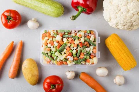 Rectangular plastic container with mix of frozen vegetables flat lay  Stock Photos