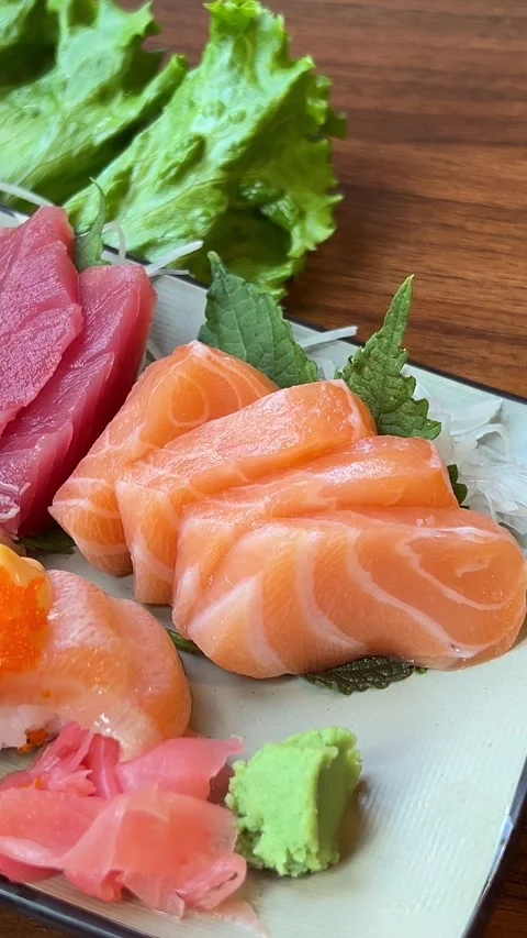 A rectangular plate of assorted sushi, including nigiri, sashimi, and tamago Stock Footage 322097436