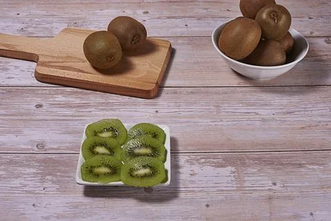 Rectangular plate with cut kiwifruit. and several whole Stock Photos