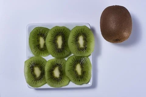 Rectangular plate with cut kiwifruit Stock Photos