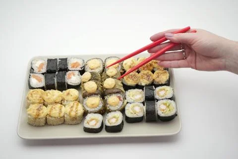 Rectangular plate full of sushi rolls and sticks of red color, on an isolated Stock Photos