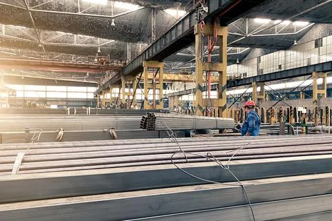 Rectangular profile metal pipes in a large warehouse, heavy construction indu Foto stock