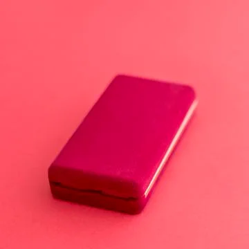 Rectangular red velvet box is closed for the chain on a red background Stock Photos