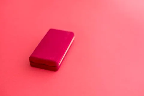 Rectangular red velvet box is closed for the chain on a red background Stock Photos